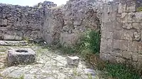 Remains of the ancient city, some walls and what appears to be a small well.