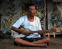 A music teacher in Mae On, near Chiang Mai, playing a sueng.