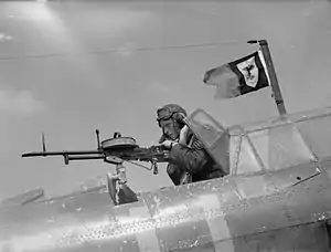 A sergeant air-gunner demonstrates a Vickers K gas-operated machine-gun.