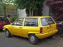  Rear-three-quarter view of a small three-door car with colour-matched bumpers.