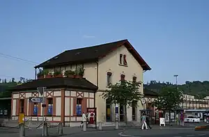 Three-story building with gabled roof and single-story wings