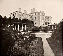 A large square garden in front of a large house