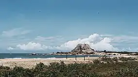 Sandy beach with a rocky outcrop in sea side