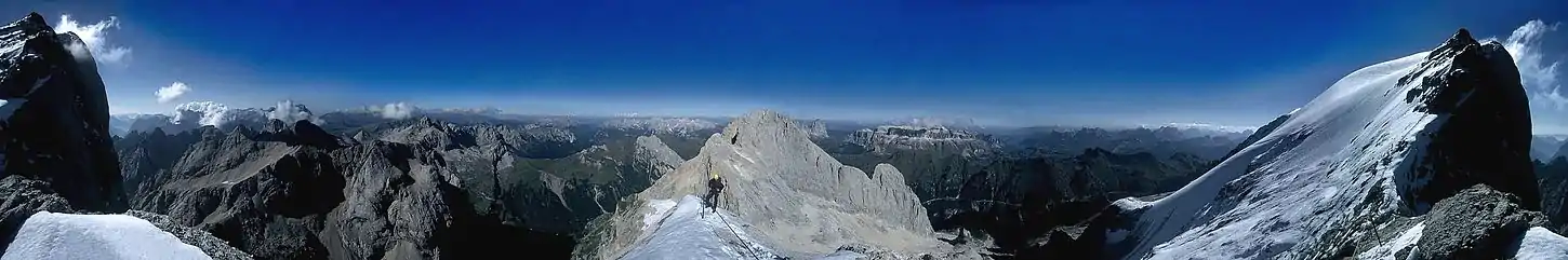 Panorama 360° ze wschodniej grani Marmolady. Po lewej i prawej szczyt Punta Penia, na horyzoncie widać masyw pala (Palagruppe), Latemar, Rosengarten, Langkofel, Sella i Dolomity Ampezzaner