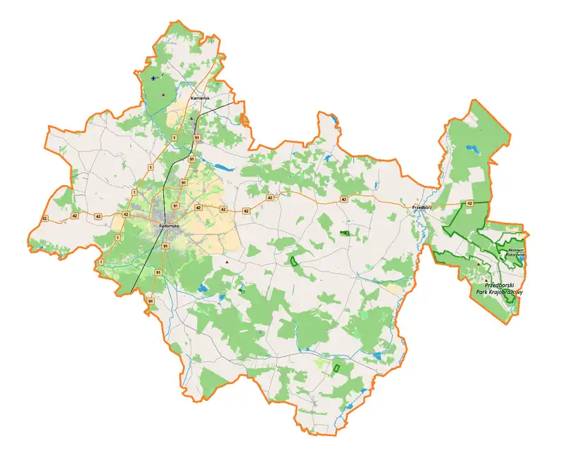 Mapa konturowa powiatu radomszczańskiego, blisko centrum na lewo znajduje się punkt z opisem „Kościół Podwyższenia Krzyża Świętego w Radomsku”